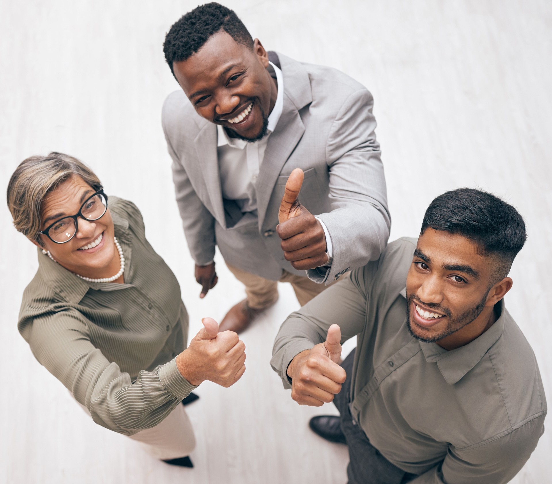 Shot of a group of businesspeople showing a thumbs up in an office at work